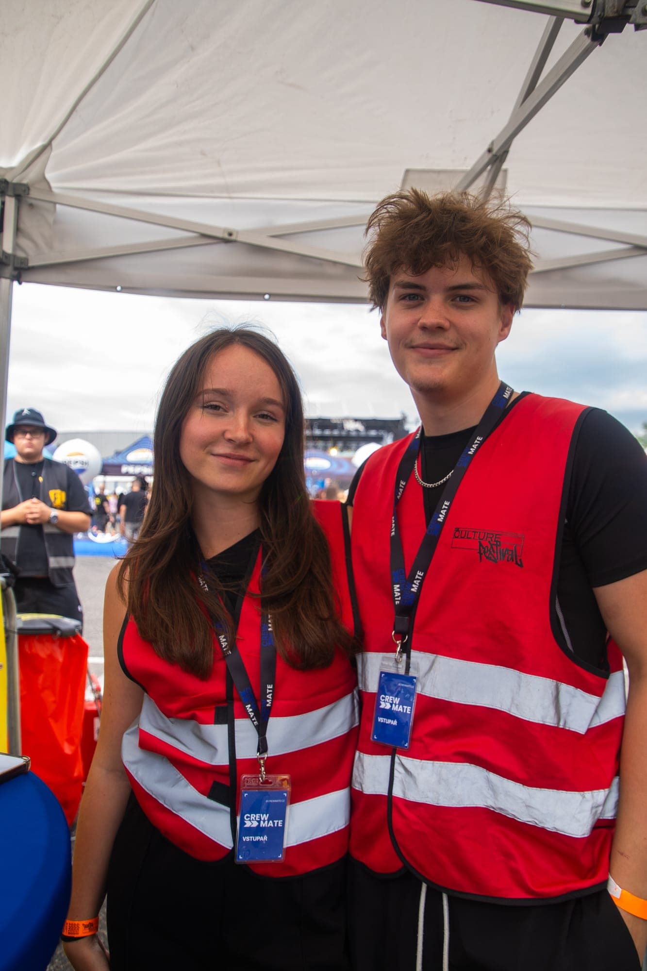 Dva členové týmu Crewmate v reflexních vestách s visačkami na festivalu